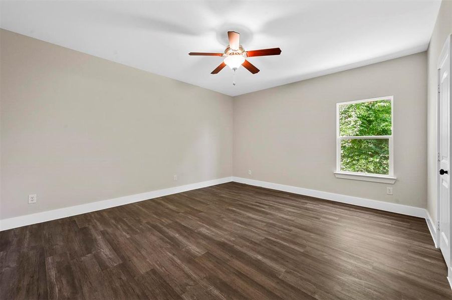 Spare room with dark wood-type flooring and ceiling fan