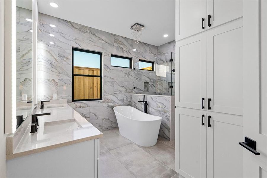 Bathroom featuring vanity, separate shower and tub, and tile walls