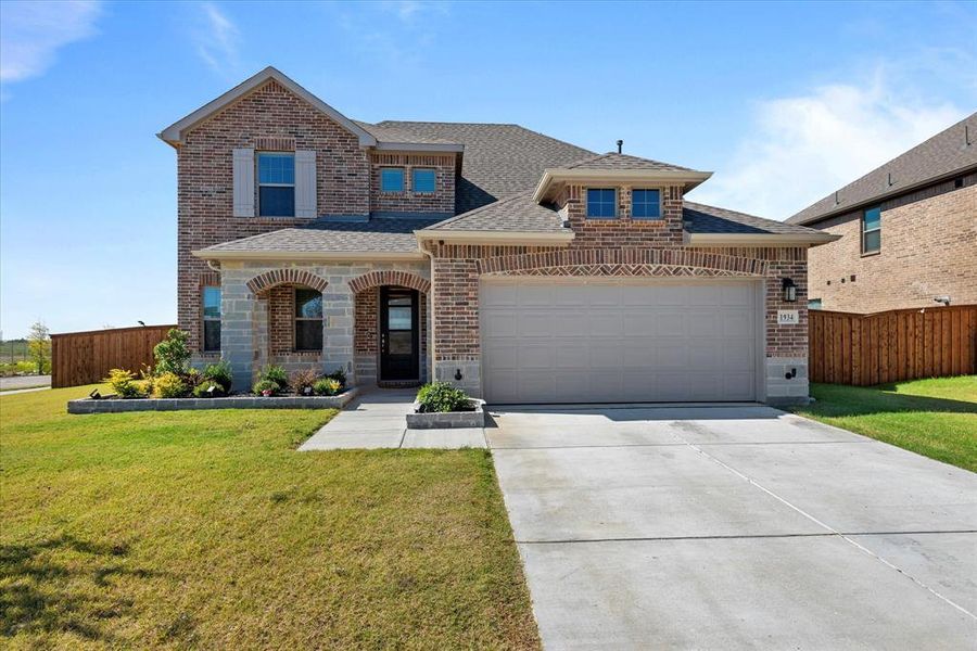 View of front of house with a garage and a front lawn