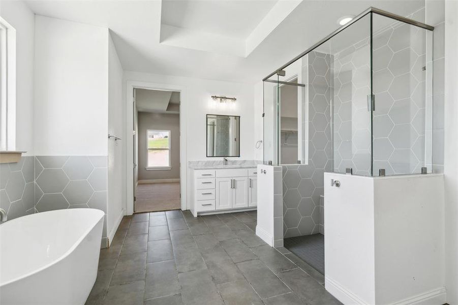 Bathroom with shower with separate bathtub, tile patterned floors, vanity, and a tray ceiling