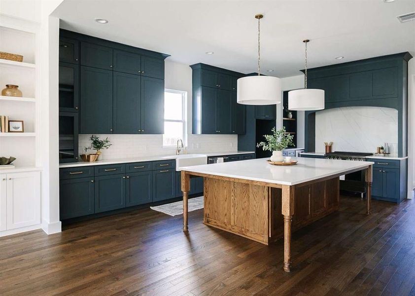 Kitchen featuring blue cabinets, tasteful backsplash, a center island, decorative light fixtures, and dark hardwood / wood-style floors