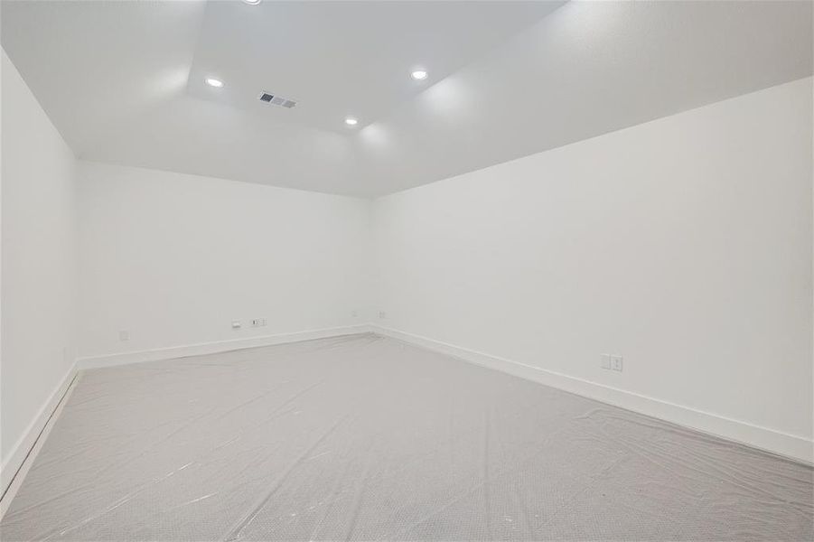 Media room with vaulted ceiling and dry bar