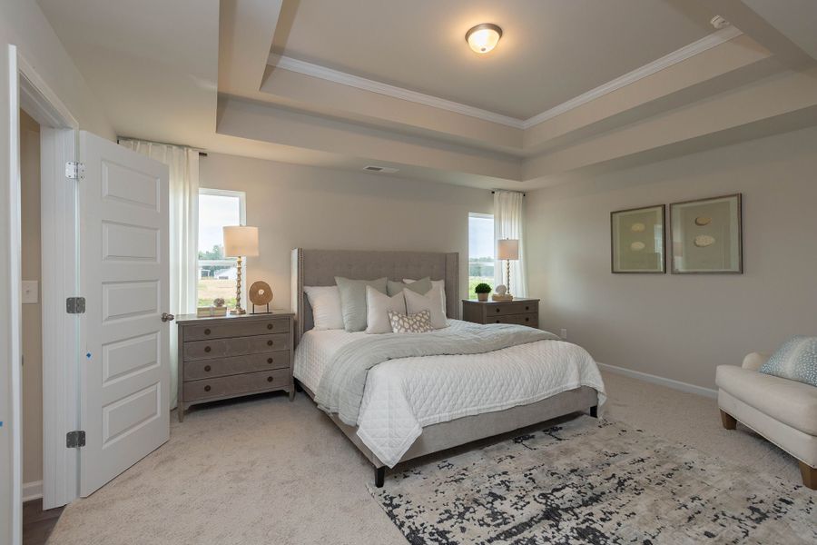 Desirable primary bedroom with a tray ceiling