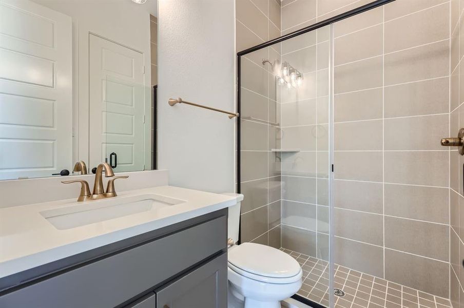 Bathroom featuring walk in shower, vanity, and toilet