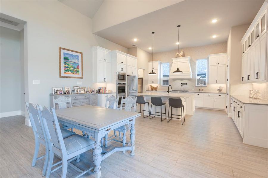 Dining area featuring light wood-type flooring and lofted ceiling