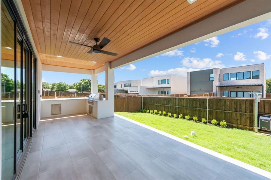 View of patio with exterior kitchen, ceiling fan, and grilling area