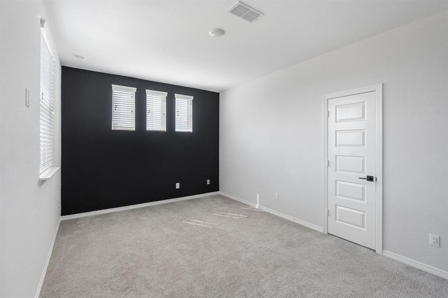 The game room features plush carpet and an accent wall.