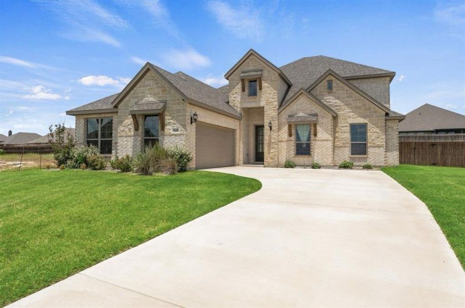 French country home with a front lawn and a garage