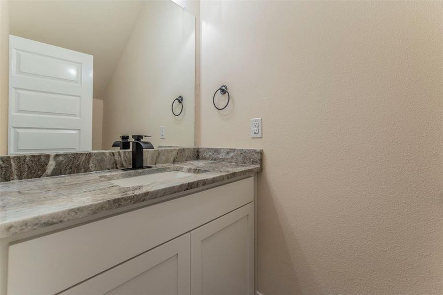 Bathroom with vanity and vaulted ceiling