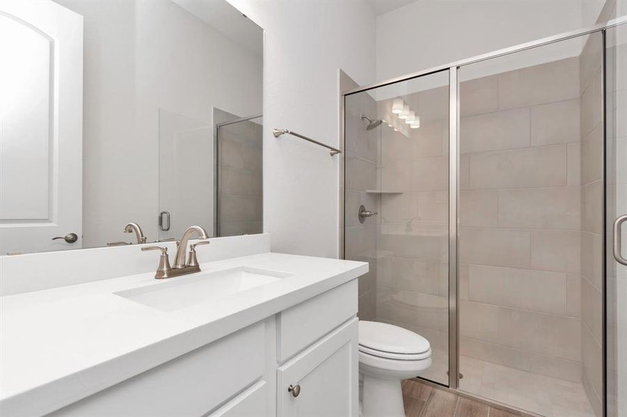 An ensuite bathroom features an walk-in shower.
