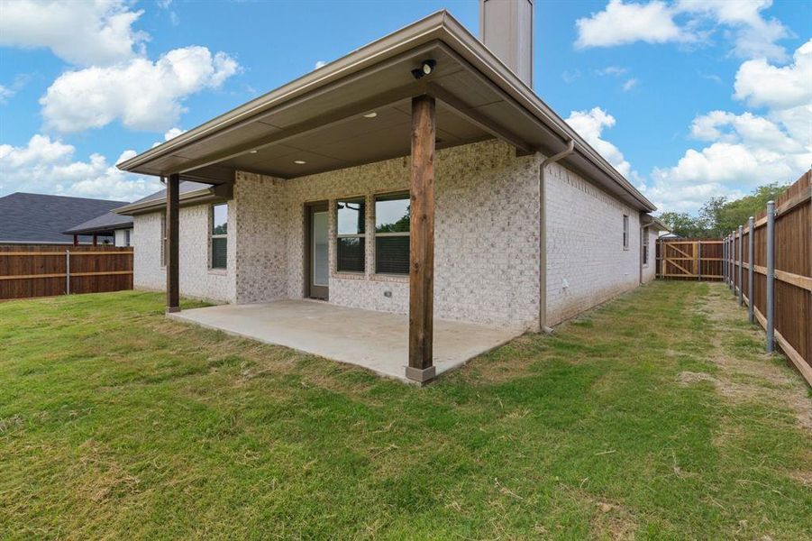 Back of house featuring a lawn and a patio