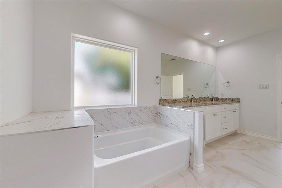 Primary Bathroom with vanity and a bathing tub