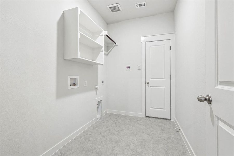 Clothes washing area featuring light tile patterned flooring, electric dryer hookup, hookup for a gas dryer, and hookup for a washing machine