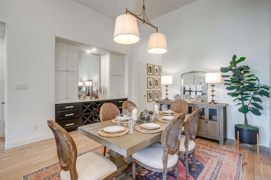 Dining room with light wood-type flooring and high vaulted ceiling