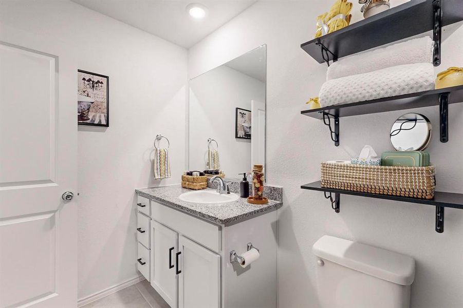 Bathroom featuring vanity, toilet, and tile patterned floors