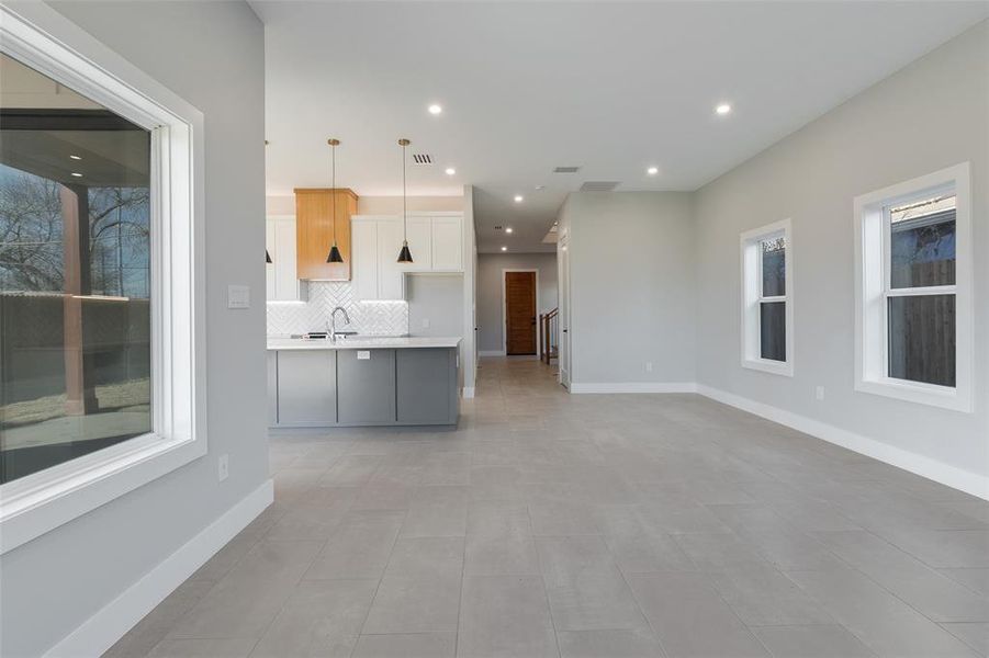 Unfurnished living room with light tile patterned flooring and sink