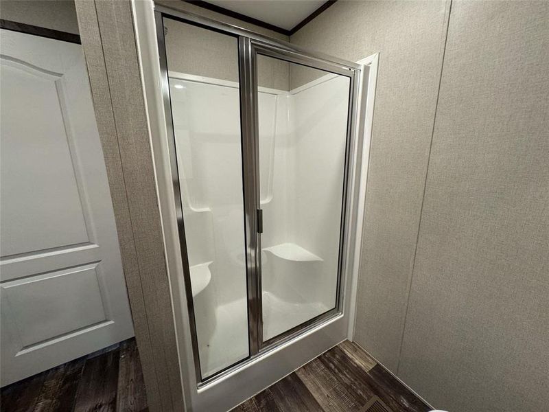 Bathroom with an enclosed shower and hardwood / wood-style floors