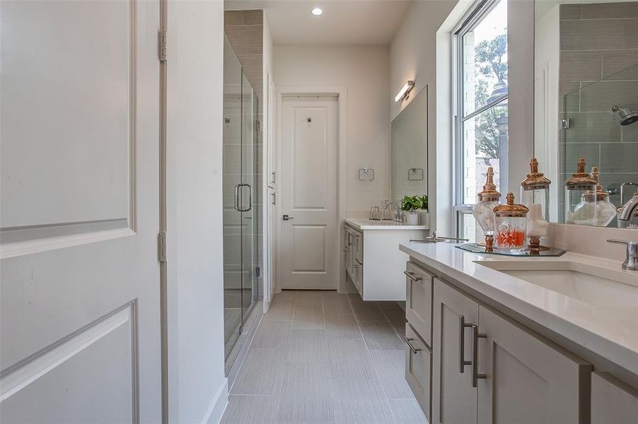 Bathroom featuring walk in shower, tile flooring, and vanity