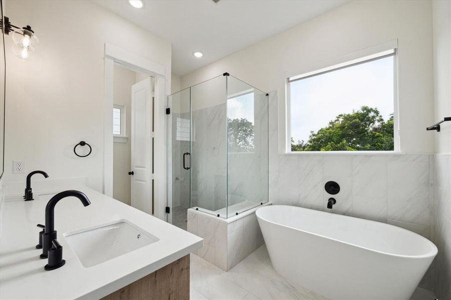 The primary bathroom is equipped with a free standing bathtub and stand alone shower with ceramic tiles.