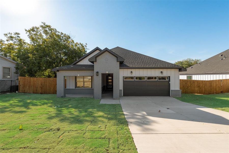 View of front of home with a front lawn and a garage