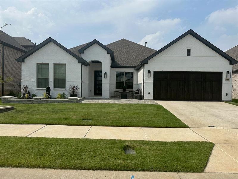 View of front facade with a garage and a front lawn