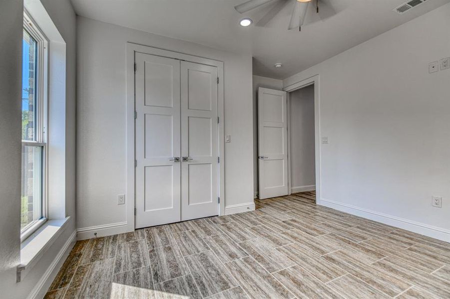 Unfurnished bedroom with a closet, ceiling fan, and light wood-type flooring