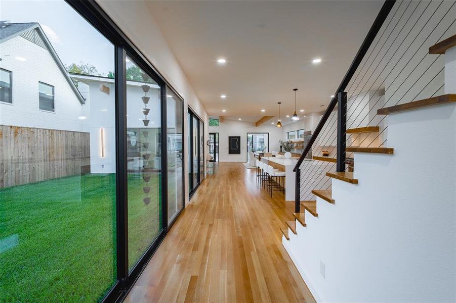 Corridor with light hardwood / wood-style flooring and floor to ceiling windows