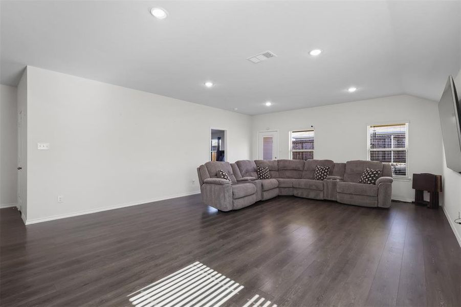 Living room featuring lofted ceiling and dark hardwood / wood-style floors