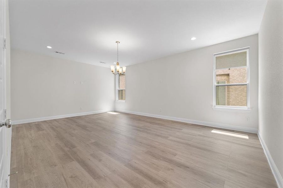 Unfurnished room featuring light hardwood / wood-style flooring and a chandelier