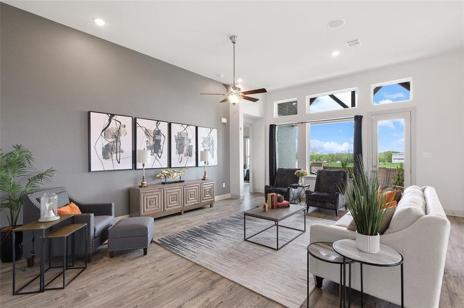 Living room with ceiling fan and light hardwood / wood-style floors