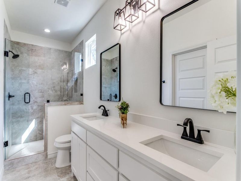 Bathroom with vanity, tile patterned floors, toilet, and walk in shower