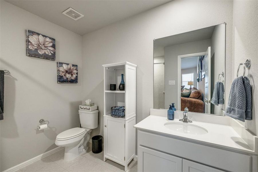 Bathroom featuring tile patterned flooring, vanity, and toilet