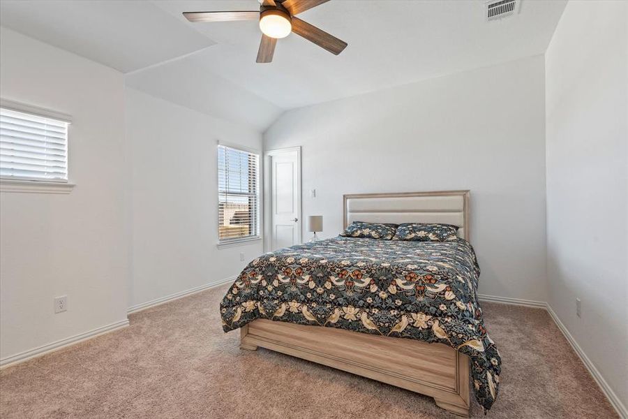 Bedroom with lofted ceiling, carpet, and ceiling fan