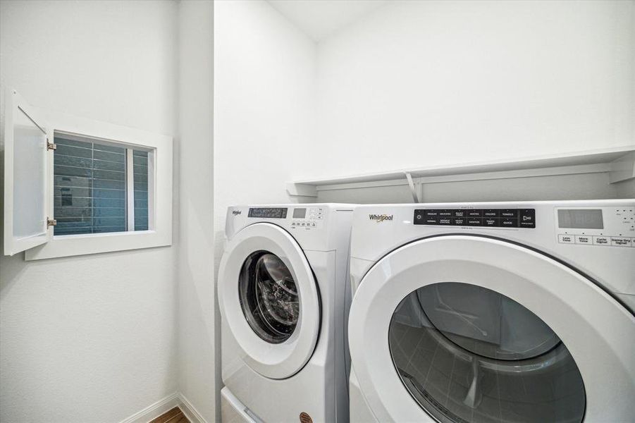 Good sized laundry room. See window leading to primary bathroom.