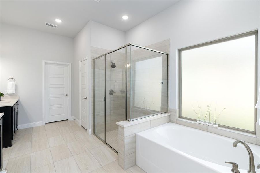 Bathroom featuring tile patterned floors, independent shower and bath, and vanity