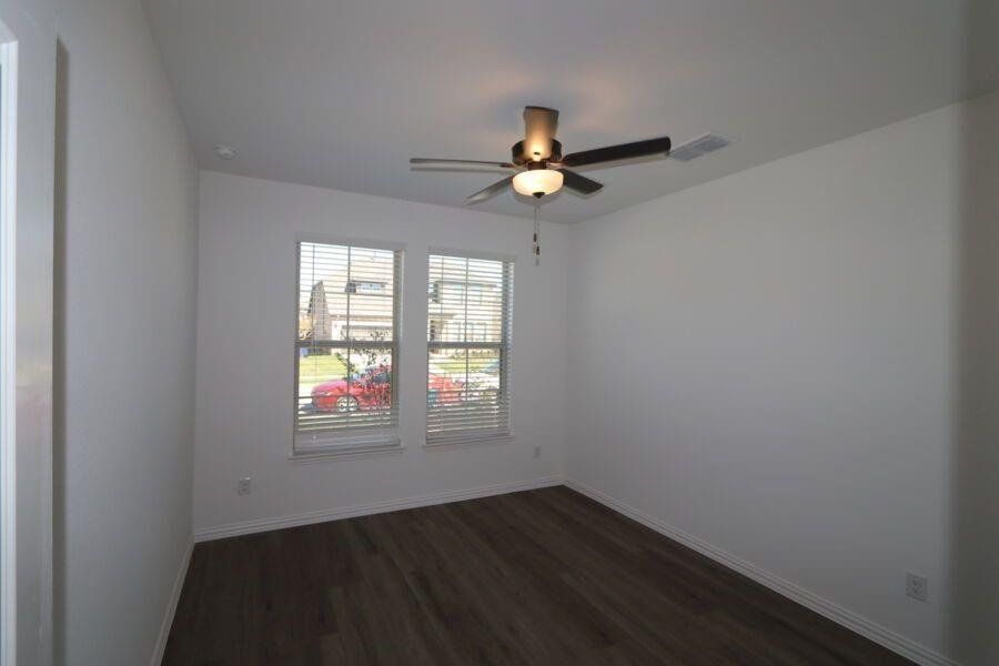 Spare room with dark hardwood / wood-style flooring and ceiling fan