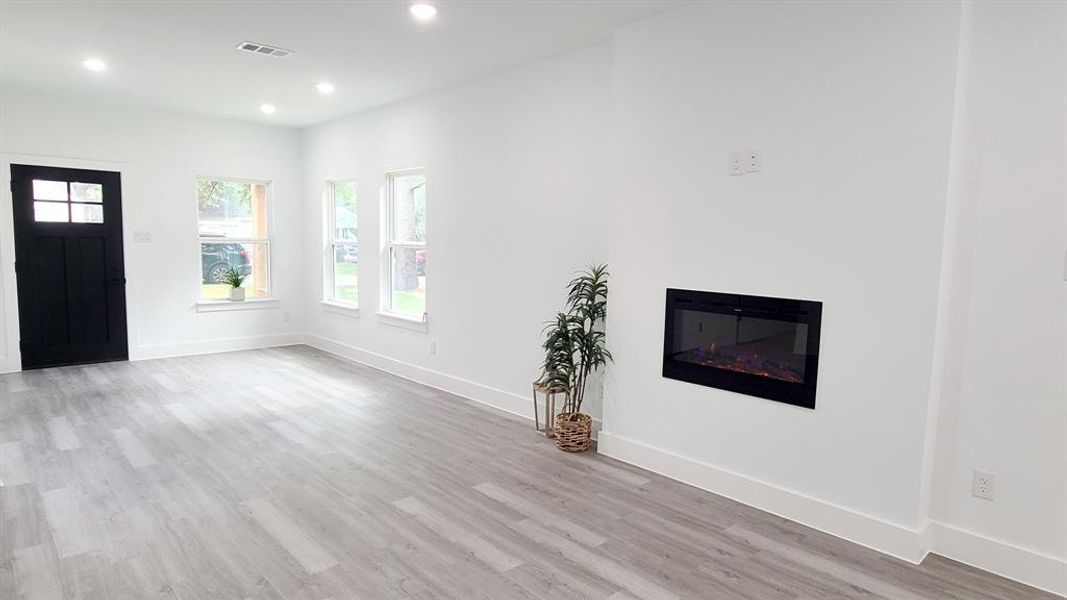 Living room with light wood-type flooring and appliance fireplace