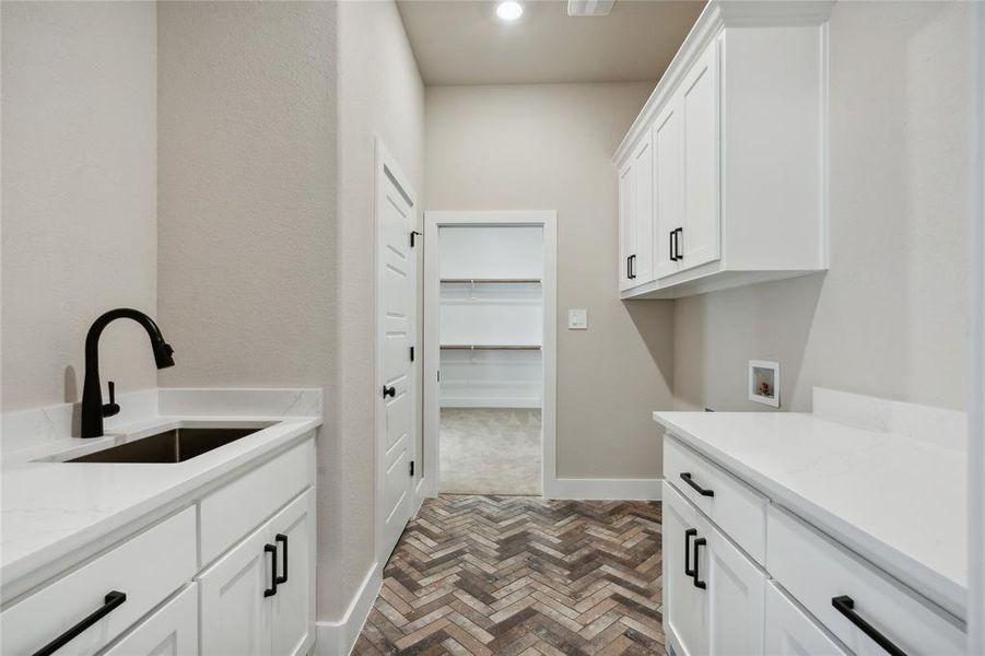 Laundry room boasts of utility closet and wash sink.