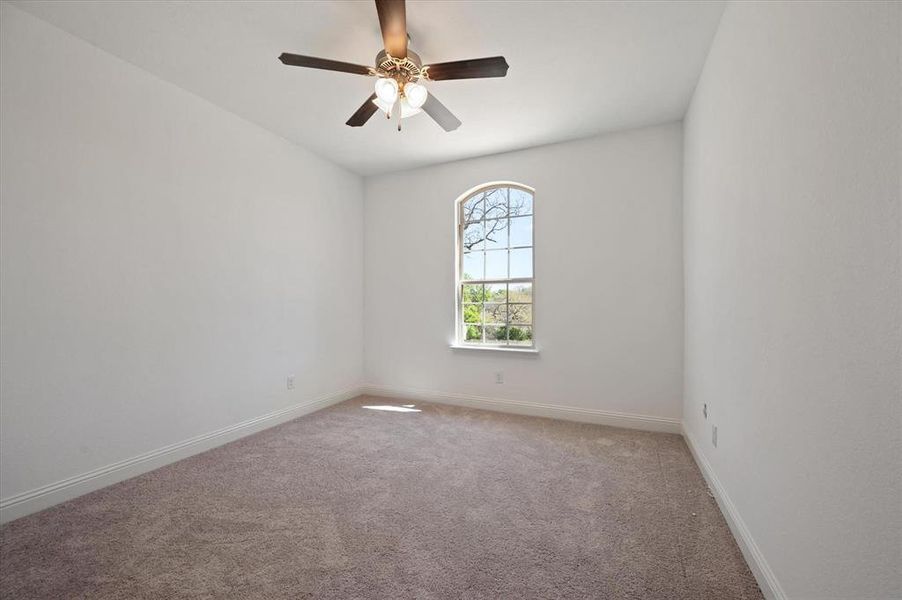 Empty room with carpet flooring and ceiling fan