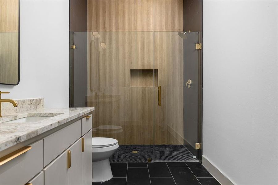 Bathroom with tile patterned flooring, vanity, toilet, and walk in shower