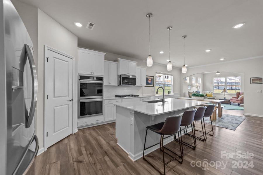 State of the art neutral kitchen with upgraded appliances, very large central island which comfortably sits 4, recessed lighting, walk-in pantry, pendant lighting and ROOM to enjoy!