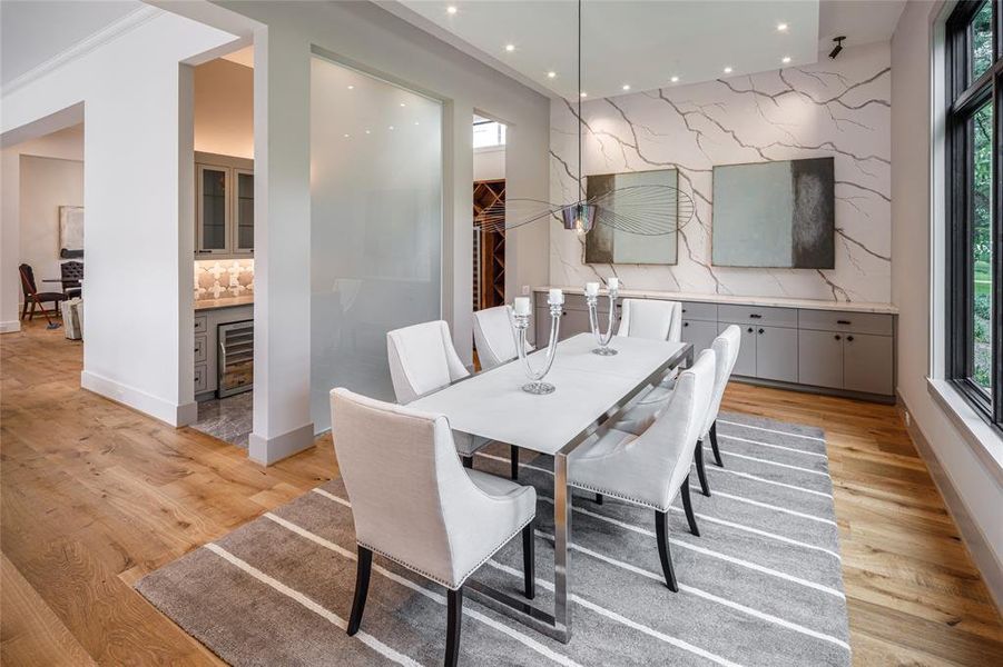 A frosted glass panel separates the formal dining and the  wet bar