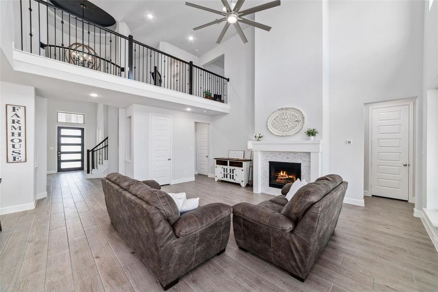 This is a spacious living room with 21 foot ceilings, a modern fireplace, elegant tile wood floors, and a second-floor balcony overlook where you can watch Stunning Texas Sunsets!