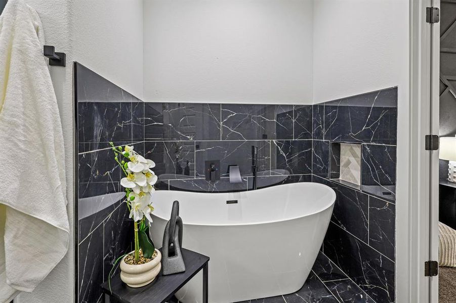 Bathroom with a bath and tile walls