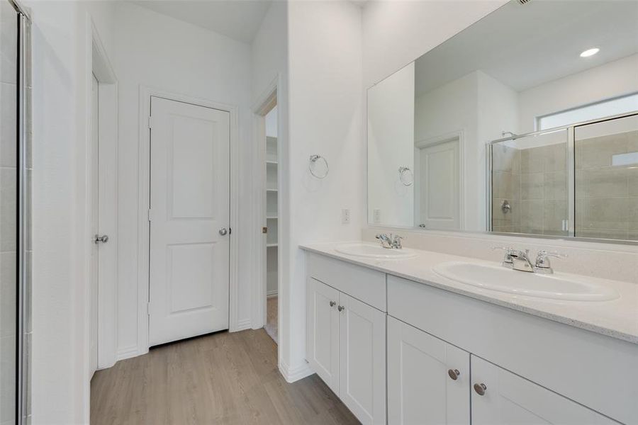 Bathroom with vanity, hardwood / wood-style flooring, and an enclosed shower