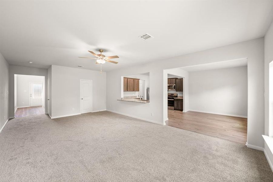 Unfurnished living room with light hardwood / wood-style floors, sink, and ceiling fan