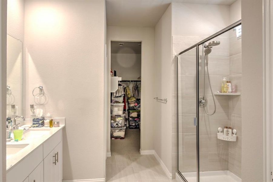 Bathroom featuring tile flooring, walk in shower, and vanity