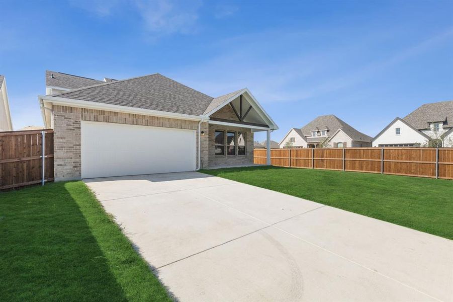 View of front of home featuring a garage and a front yard