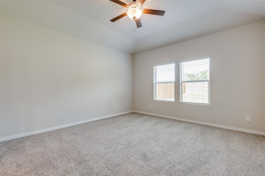 Spare room with carpet flooring, vaulted ceiling, and ceiling fan