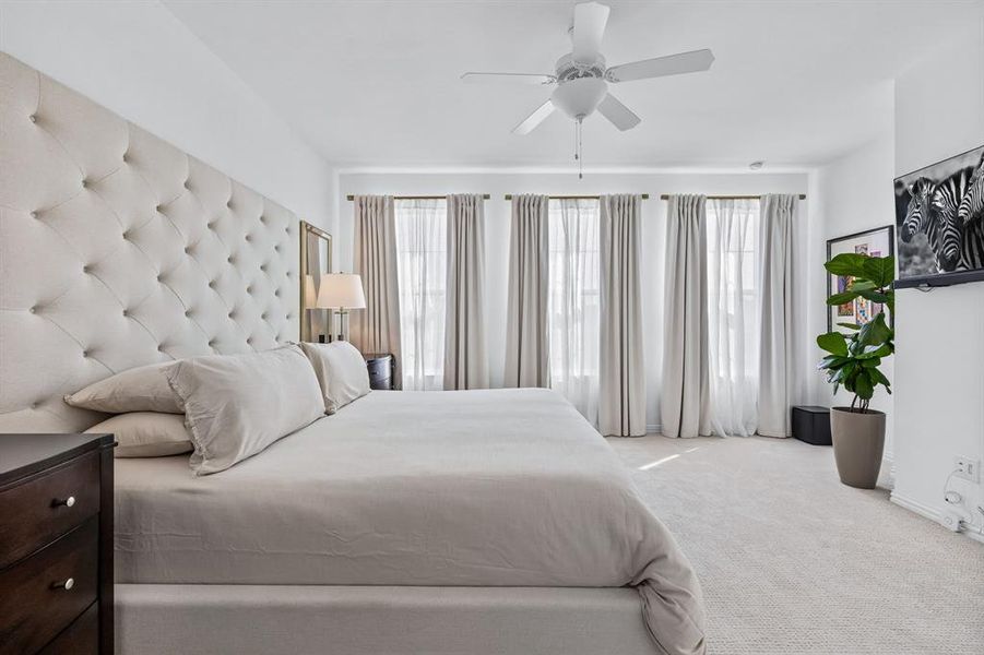 Carpeted bedroom featuring ceiling fan